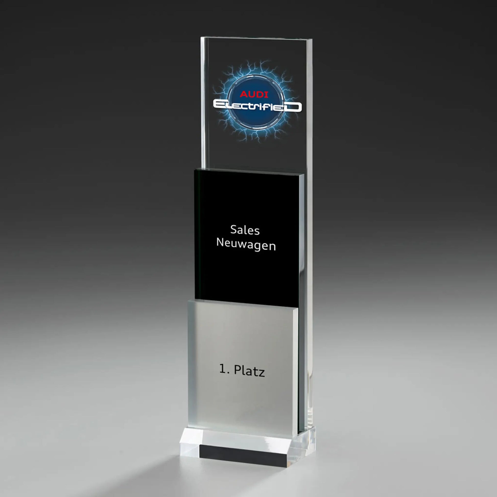 Phantom Step Award mit Digitaldruck und Lasergravur: Logo auf klarem Acrylpanel, schwarzes Mittelelement mit Kategorietext, silbernes Element mit Platzierung, klarer Sockel
