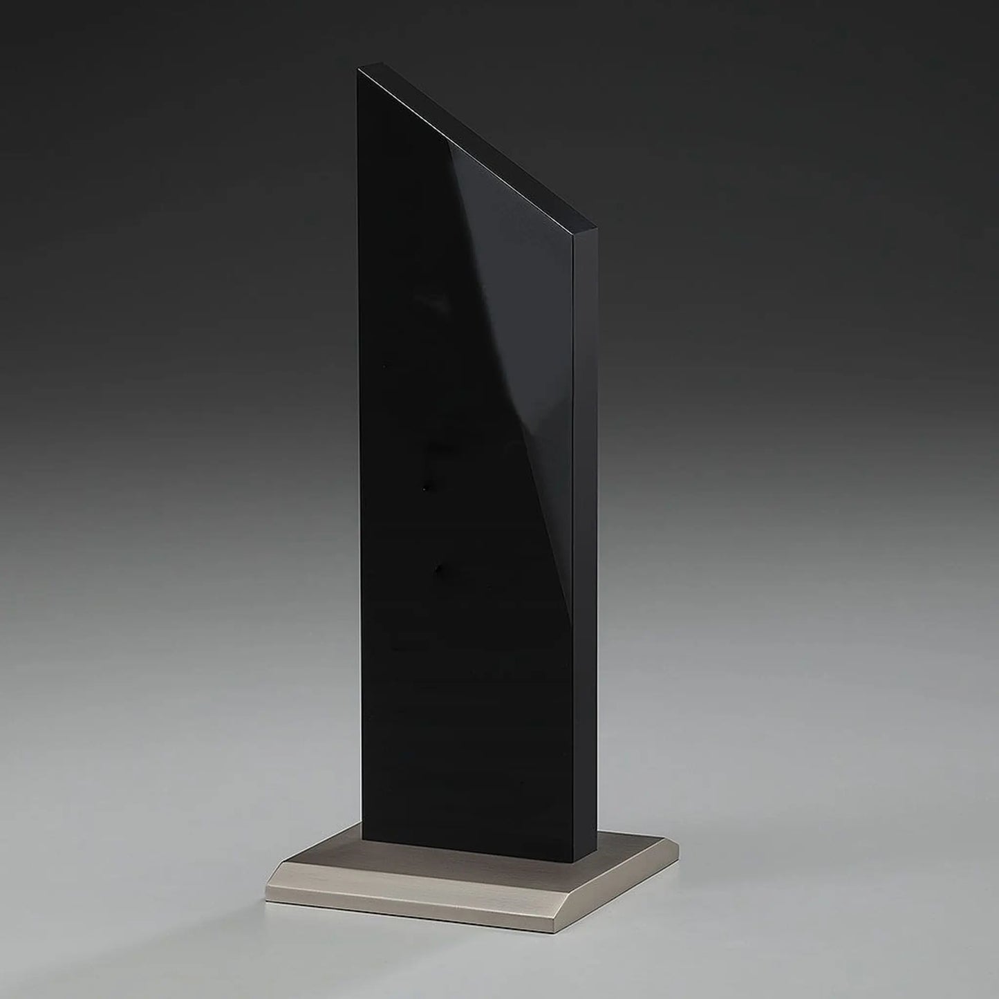Black Monument Award – schwarze Hochglanz-Acrylglas-Stele auf gebürstetem Metallsockel, hier ohne Gravur, Seitenansicht auf grauem Hintergrund
