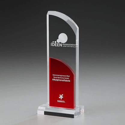 Clear Fire Wing Award mit Digitaldruck und Lasergravur: bogenförmiges klares Acrylglas-Panel mit Logo und Text, rotes halbrund geformtes Acrylelement mit Widmung, klarer Sockel 
