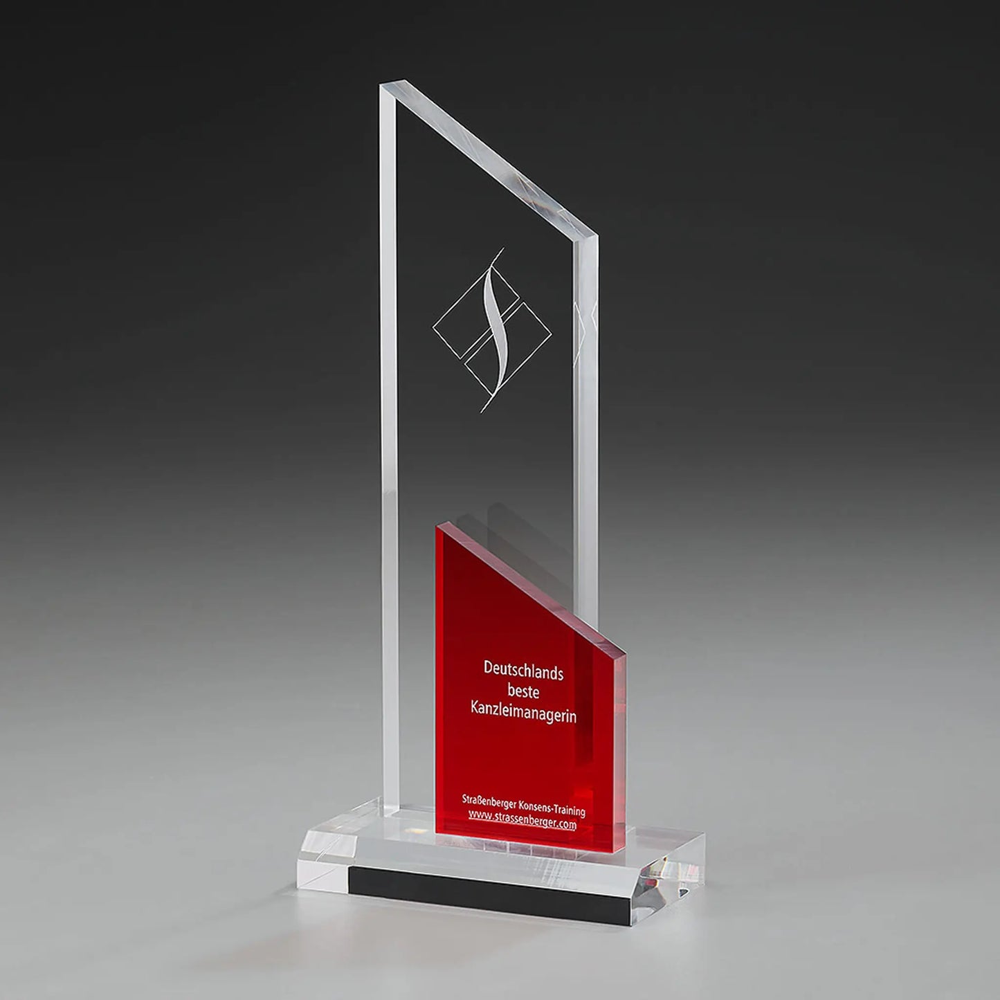 Clear Fire Peak Award mit Lasergravur und Digitaldruck: klares Acrylglas-Panel mit Logo, rotes schräggeschnittenes Acrylelement mit Widmungstext, klarer Sockel 
