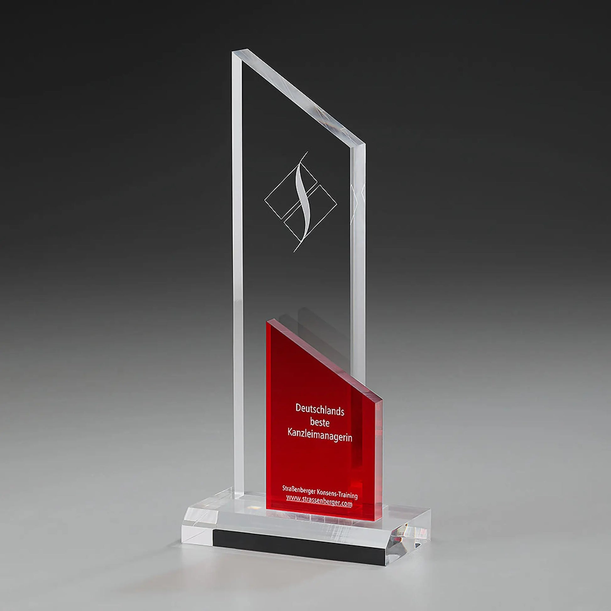 Clear Fire Peak Award mit Lasergravur und Digitaldruck: klares Acrylglas-Panel mit Logo, rotes schräggeschnittenes Acrylelement mit Widmungstext, klarer Sockel 
