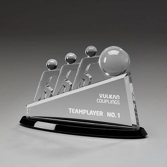 Collaboration Award aus Kristallglas – drei aufstrebende Figuren mit großer Glaskugel auf dreieckigem Glaskörper und schwarzem Sockel, Höhe 145 mm – mit Beispielgravur „Teamplayer No. 1"
