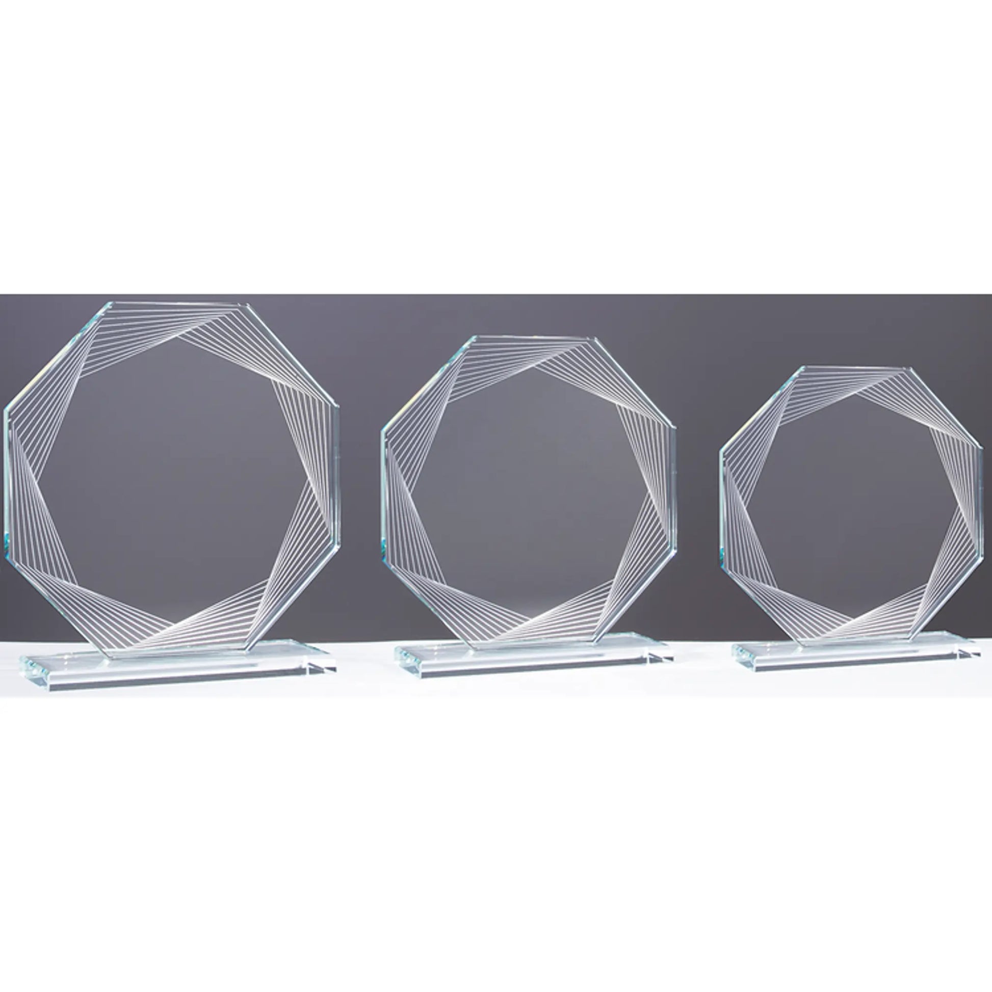 Glasaward String-Art – drei Größen im Vergleich, oktagonale Klarglas-Trophäen mit geometrischem Linienmuster, 8 mm Klarglas, auf separatem Sockel
