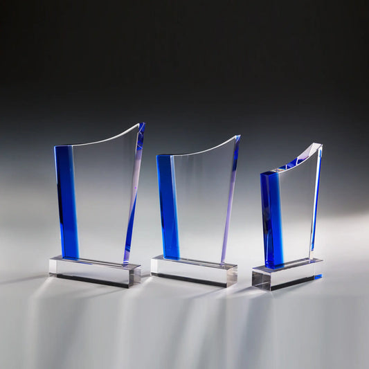 Blue Peak Award aus klarem Glas in drei Größen – Glasplatte mit blauer Seitensäule und geschwungener, spitz auslaufender Oberkante auf klarem Glassockel, ohne Gravur
