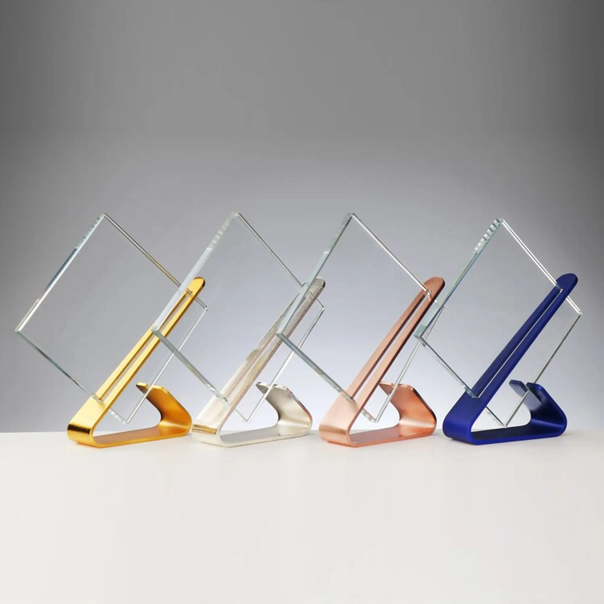 Glas-Metall Award in vier Farbvarianten: Kristallglas 10 mm mit Randschliff auf Metallständer in Gold, Silber, Bronze und Blau – Höhe 185 mm
