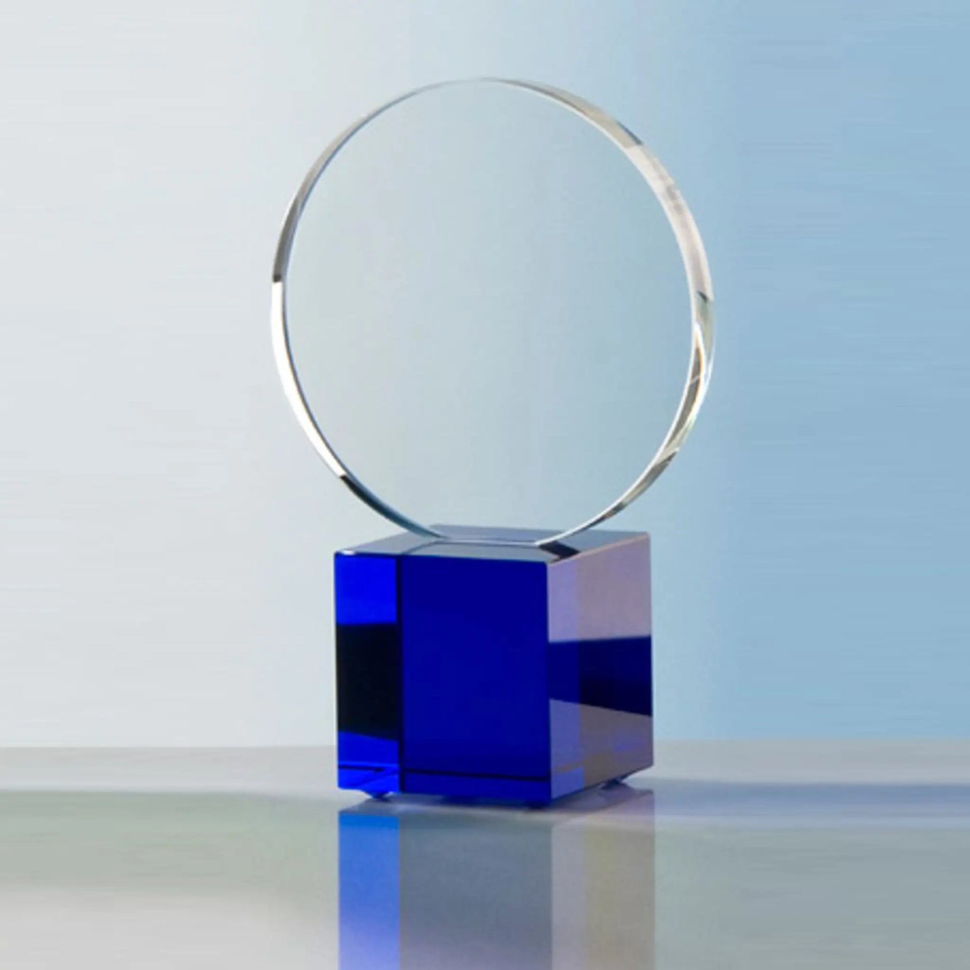 Crystal Cube Circle Award – runde Kristallglasscheibe auf blauem Kristallglas-Würfelsockel, Frontansicht, blank ohne Gravur, personalisierbar mit Lasergravur
