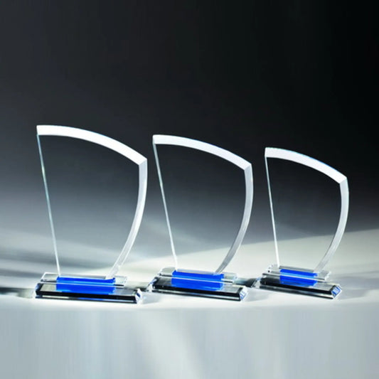 Blue Element Award aus klarem Glas in drei Größen – geschwungene, segelförmige Glasplatte auf Glassockel mit blauem Glaselement, ohne Gravur
