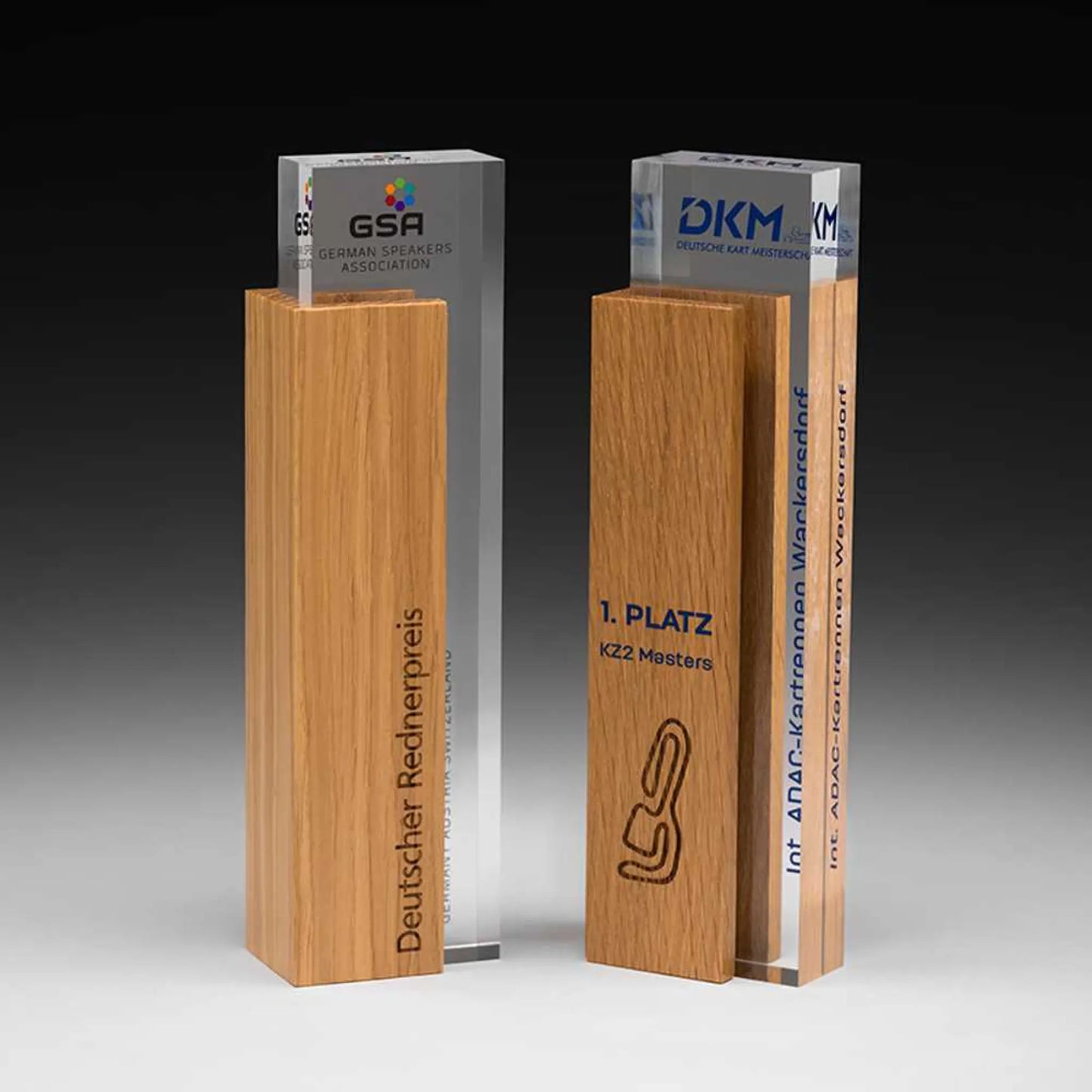 Handsome Holz-Award – zwei personalisierte Exemplare nebeneinander, Eichenholz mit Acrylglas-Säule, Lasergravur und Digitaldruck, ideal für Unternehmensauszeichnungen und Golfturniere
