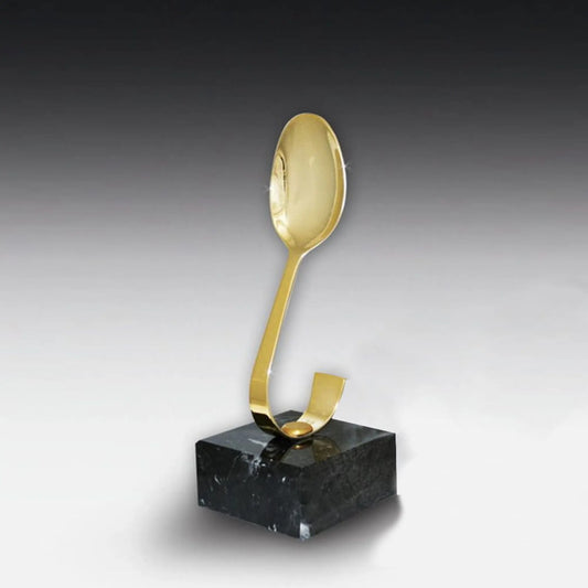 Löffel-Award goldfarben glanzlackiert auf schwarzem Marmorsockel – gebogener Metalllöffel mit Hochglanz-Goldfarben lackiert, Höhe 200 mm
