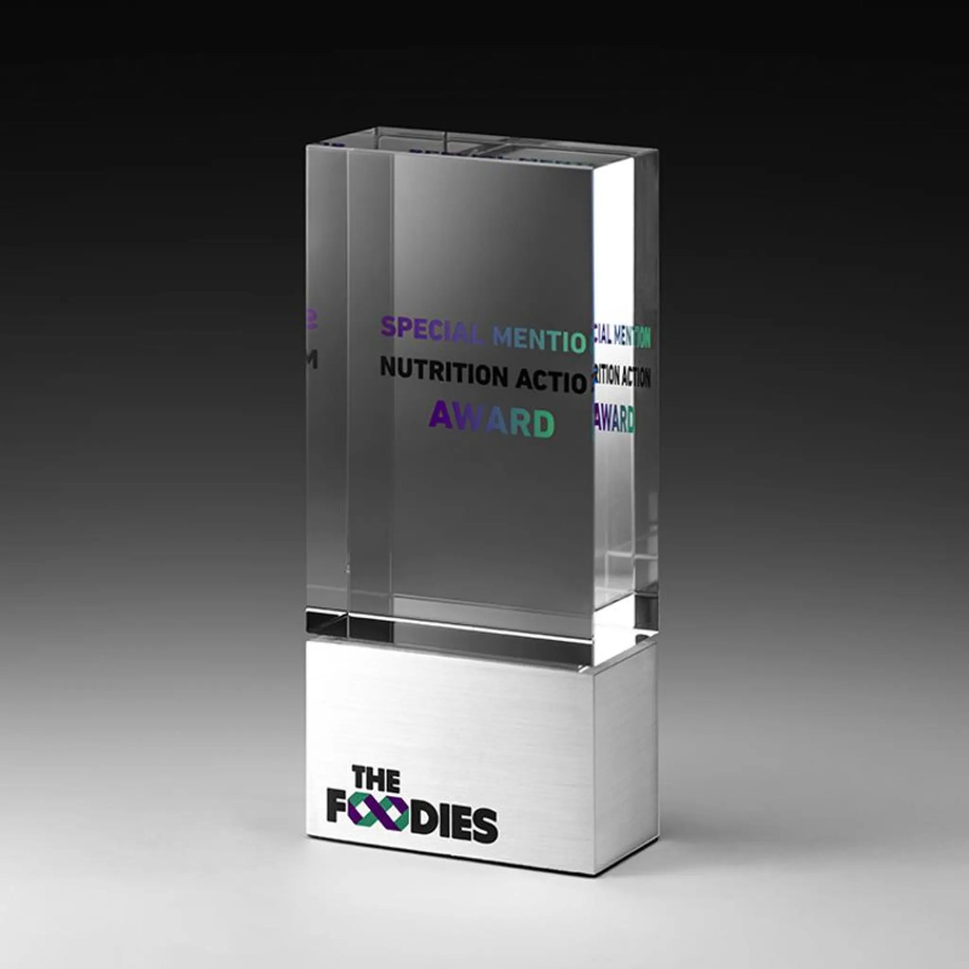NEXUS Award – massiver rechteckiger Kristallglas-Block auf poliertem Metallsockel, farbiger Digitaldruck mit Logo auf Sockel und Lasergravur mit Text im Glas, personalisierbar für Unternehmensauszeichnungen und Gala-Abende
