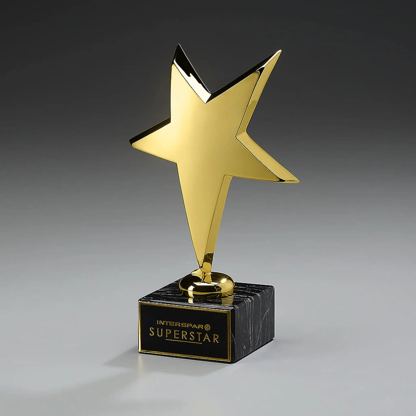 Rising Star Award – goldfarben glanzlackierter Stern-Pokal auf schwarzem Marmorsockel mit Gravurschild und Logo, dynamisch geneigt, ideal für Mitarbeiter-Awards, Gala-Abende und Unternehmensauszeichnungen
