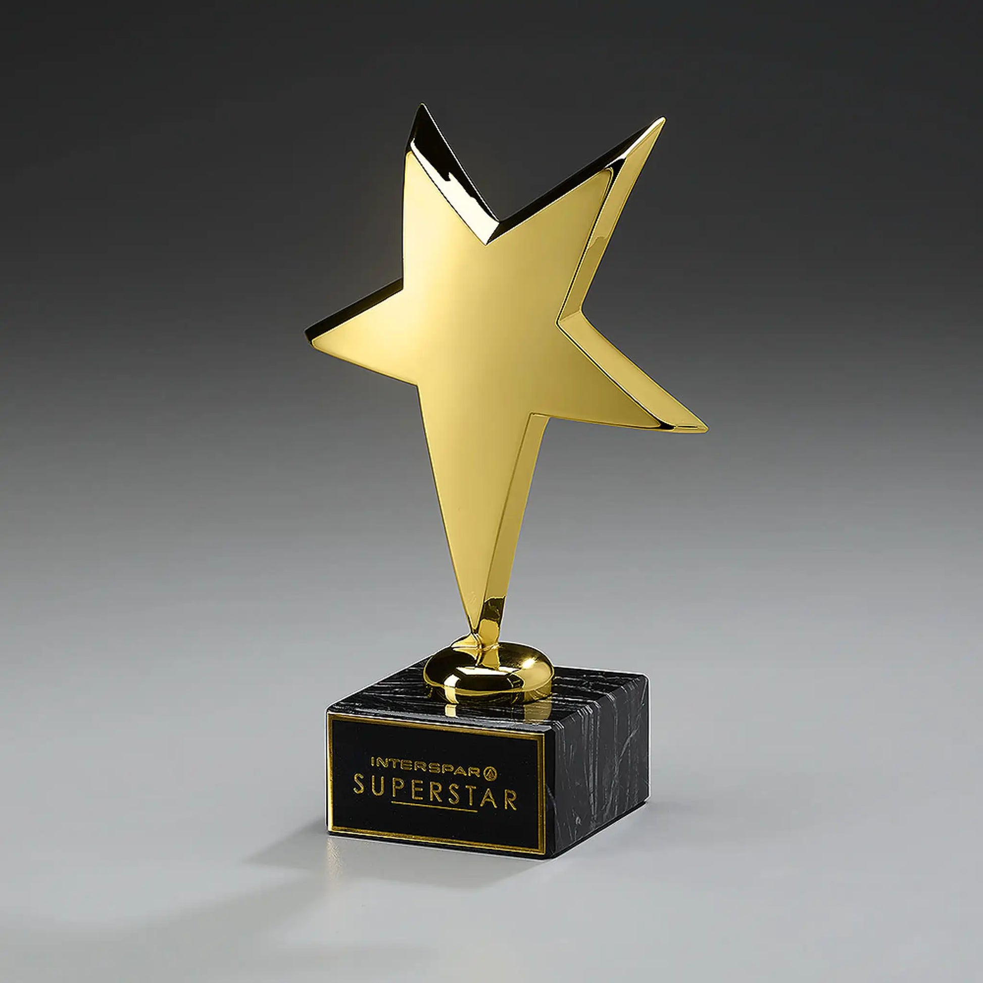 Rising Star Award – goldfarben glanzlackierter Stern-Pokal auf schwarzem Marmorsockel mit Gravurschild und Logo, dynamisch geneigt, ideal für Mitarbeiter-Awards, Gala-Abende und Unternehmensauszeichnungen
