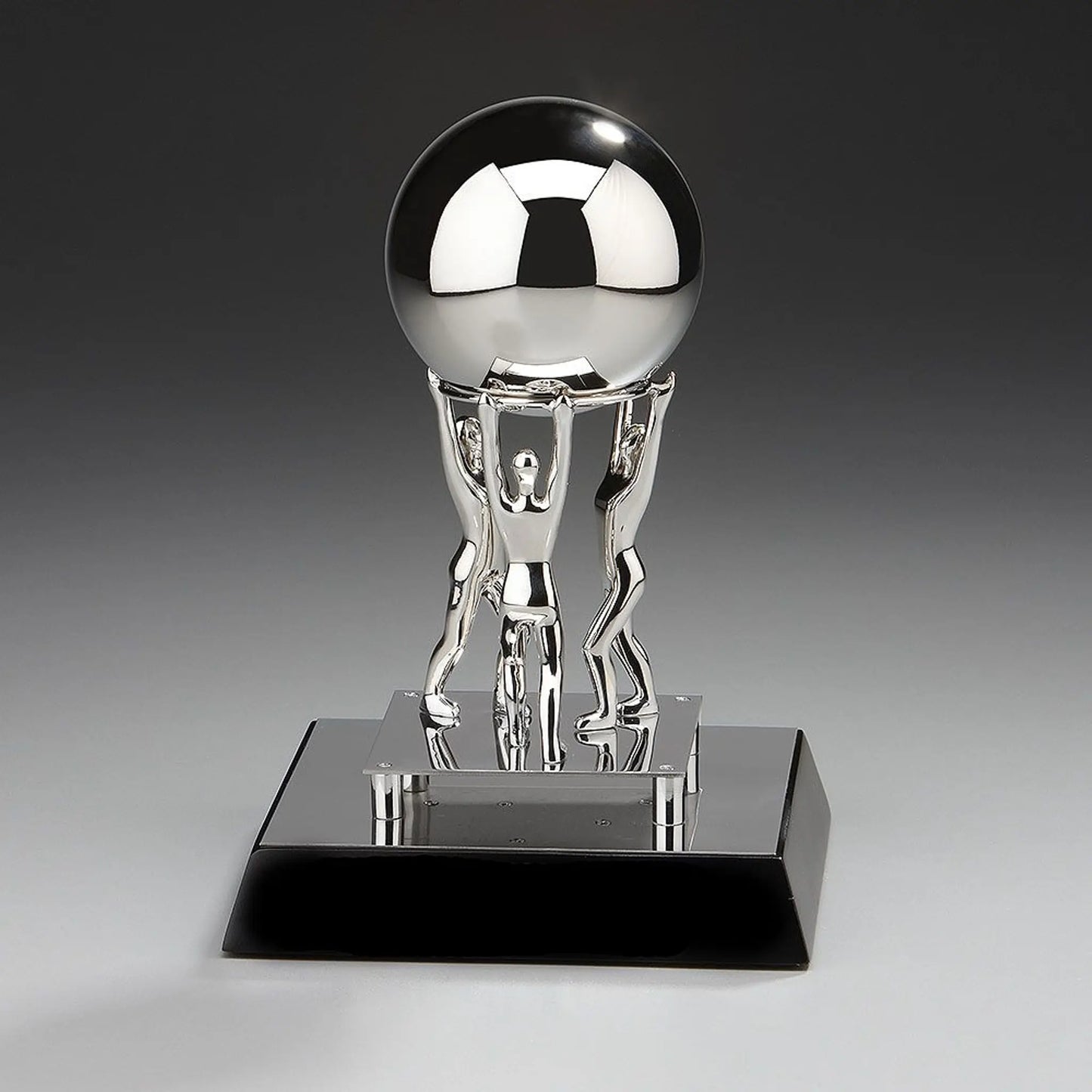 Teamwork Metal Award „Together We Can" – drei vernickelte Metallfiguren stemmen gemeinsam einen Edelstahlball, alles montiert  auf schwarzem Holzsockel, Höhe 200 mm
